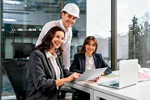 Hombres y mujeres trabajando en un proyecto con hojas y un computador