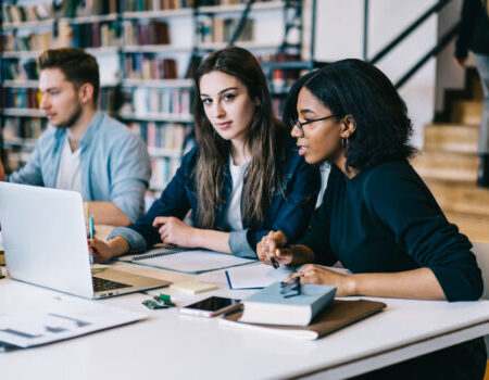 Estudiantes en biblioteca haciendo investigación